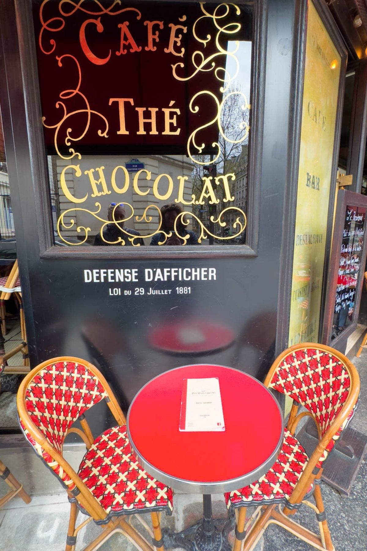 Red table and chairs outside a Parisian cafe.